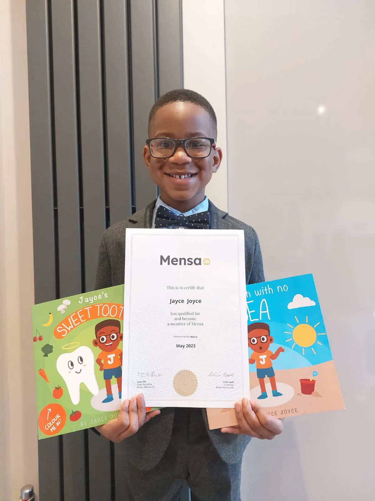 Jayce Joyce with his MENSA membership certificate and books